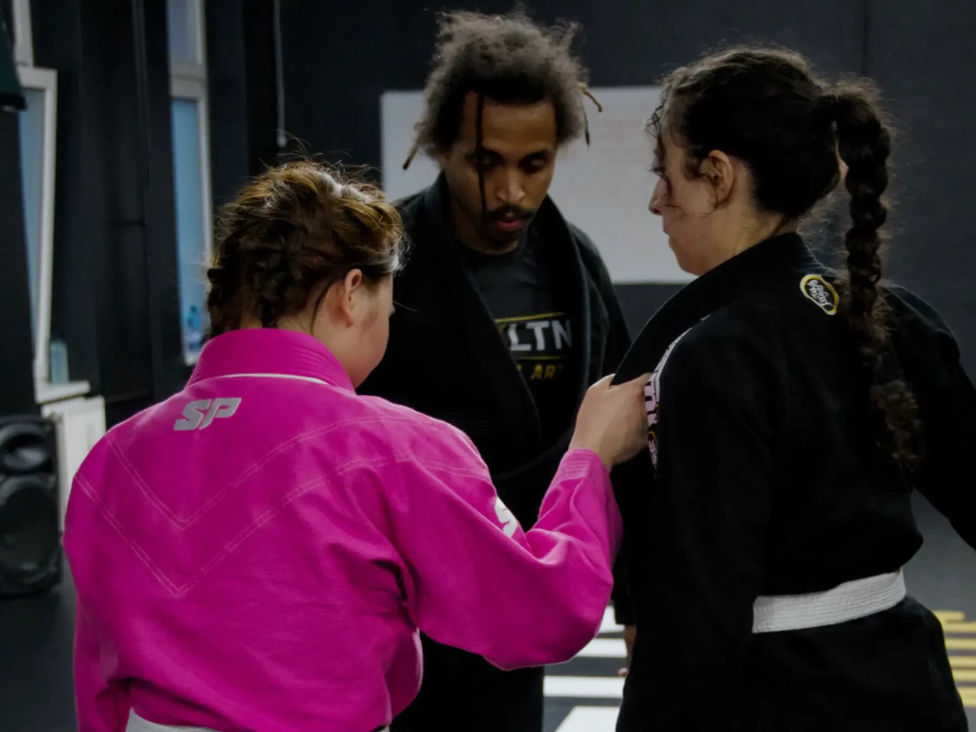 Gi-Training: zwei Frauen in Kimono, Head Coach mit EVLTN-Shirt auf der Matte in Berlin-Steglitz
