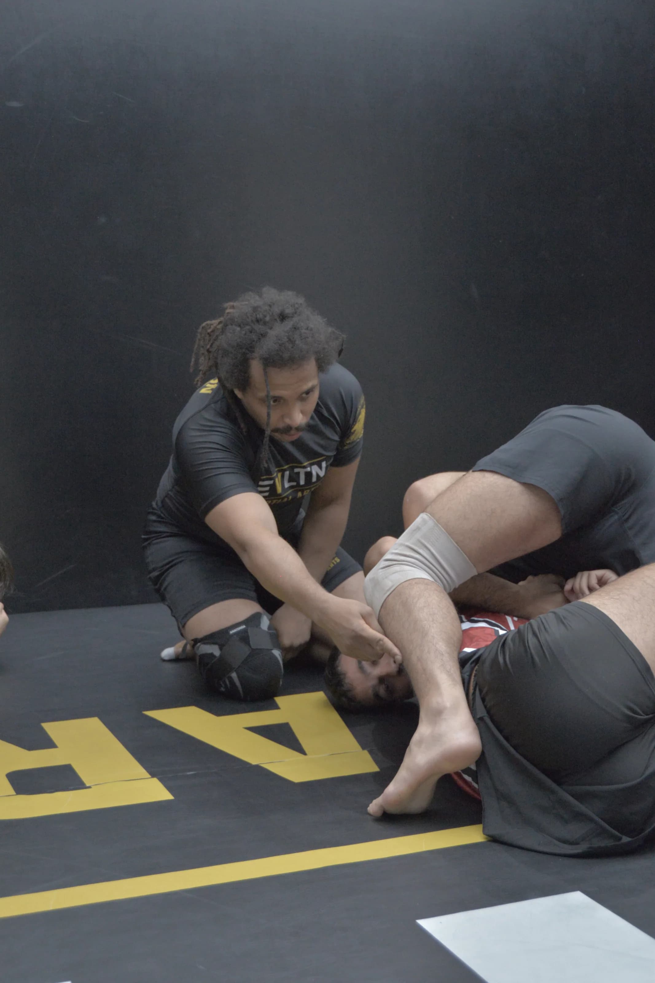 BJJ Head Coach Oussema Becha erklärt eine Beinposition im NoGi-Unterricht bei EVLTN