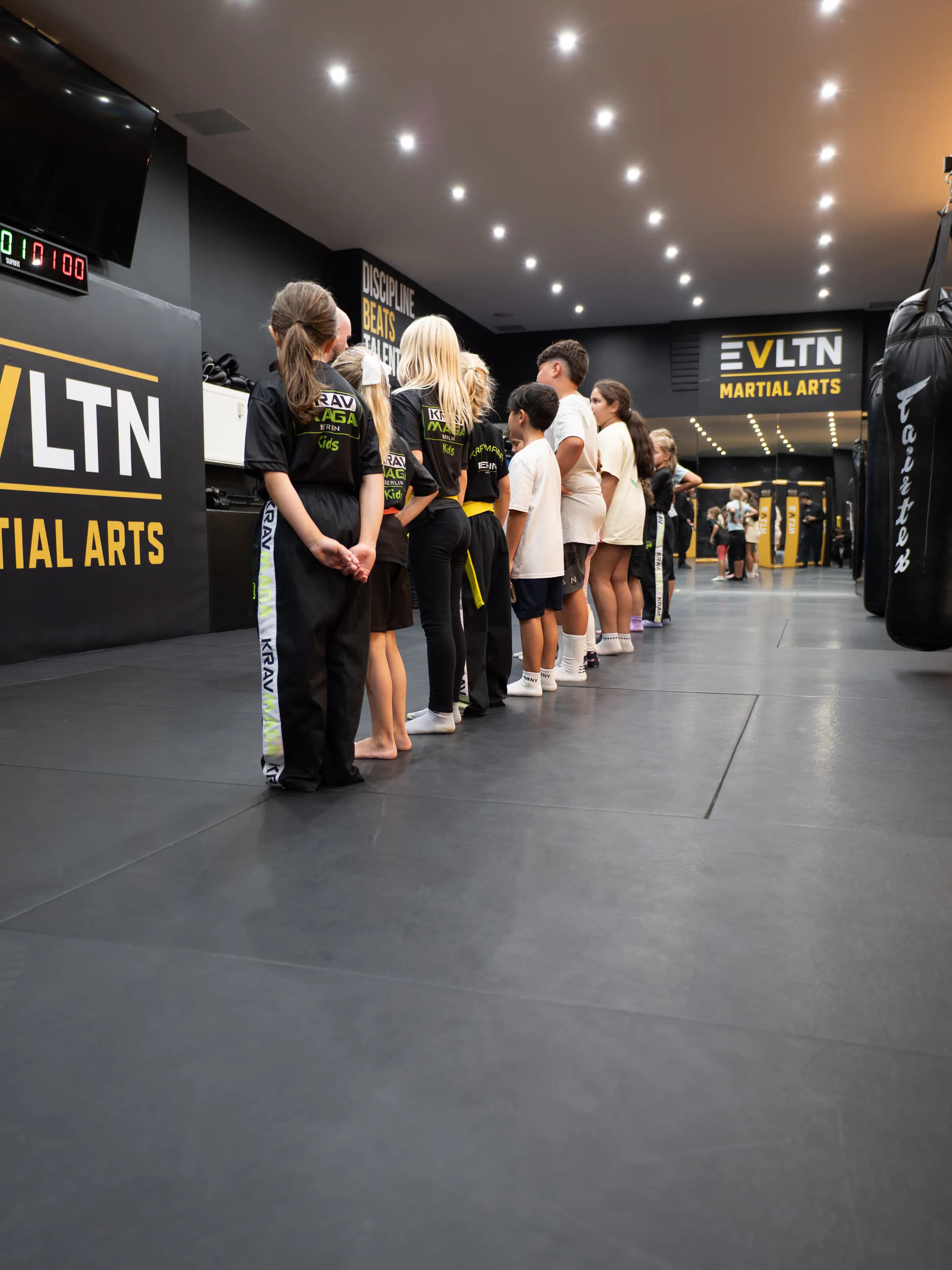 Kinderreihe mit Krav-Maga-Kids-Shirts vor Discipline Beats Talent bei EVLTN Martial Arts in Berlin-Steglitz