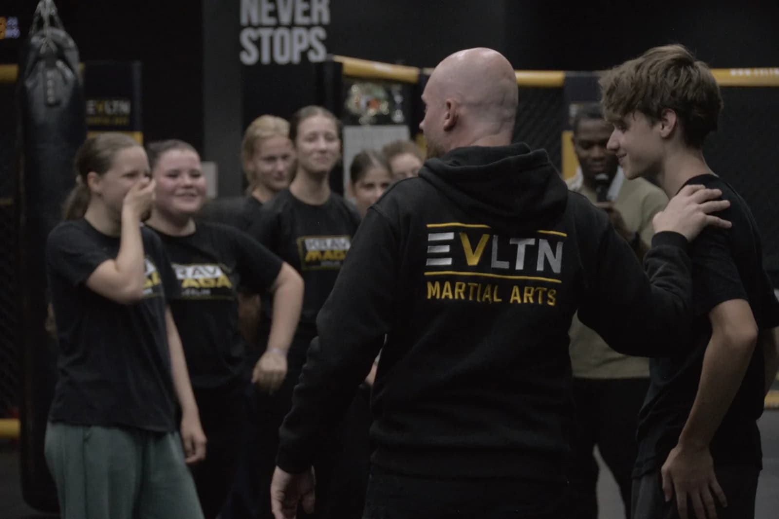 Trainer erklärt einer Gruppe Jugendlicher eine Technik im Krav-Maga-Training